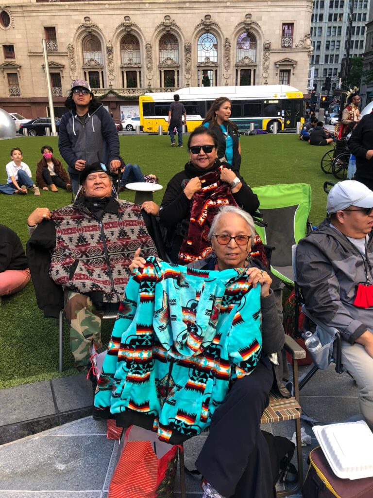 ICCT volunteer presenting gifts to an American Indian elder.