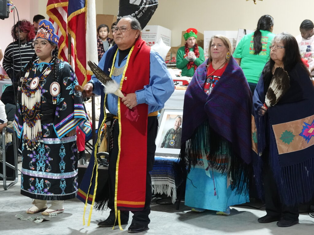 Powwow dancers performing in traditional regalia at a community event.