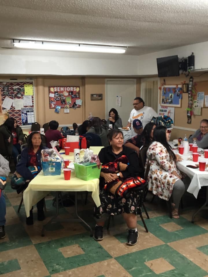 American Indian elders gathered beneath a sign labeled ‘Seniors’ at an ICCT event.